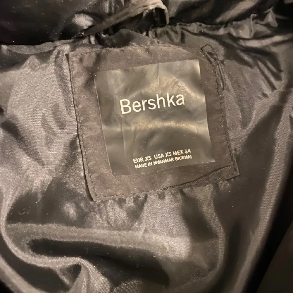 Säljer en svart pufferjacka från Bershka i storlek XS. Jackan har en dragkedja framtill och är perfekt för kalla dagar. Den är i mycket bra skick och har en stilren design med långa ärmar och en mysig huva. Perfekt för höst och vinter!. Jackor.