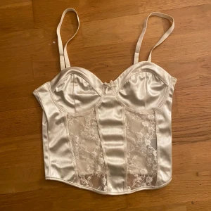 Vit festtopp från H&M Divided - Superfin topp ifrån H&M Divided! Passar perfekt till fest. Köpt för ett tag sedan men endast använd ett fåtal gånger då jag inte hittade så mycket användning för den. Toppen är lite vit/beigeaktig i färgen. Skriv till mig om ni är intresserade! 