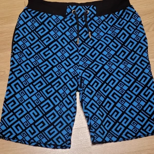 Blå mönstrade shorts från Glorious Gangsta - Säljer ett par blå och svarta shorts från Glorious Gangsta i storlek XS. De har ett coolt geometriskt mönster och snörning i midjan för perfekt passform. Perfekta för sommardagar eller avslappnade tillfällen. 🌀