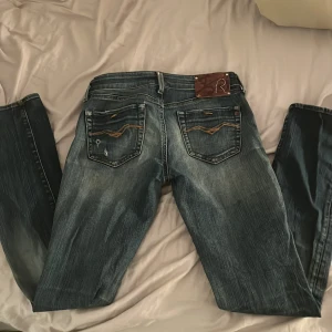 Blå jeans från Replay - Säljer ett par snygga blå jeans från Replay i bra skick. De har en klassisk femficksdesign med snygga detaljer och en knappgylf. Perfekta för både vardag och fest! 🕺