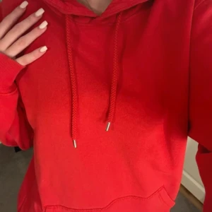 Röd hoodie - Säljer en supermysig röd hoodie som är perfekt för kyliga dagar. Den har en stor ficka fram och justerbara snören i luvan. Passar perfekt för en avslappnad stil eller när du bara vill mysa hemma. 🥰