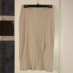 Kjol - Kjolen är kvartslång och har ett snitt som gör att lite av låret syns. Kjolen är i ganska tjockt material vilket gör att den värmer. 