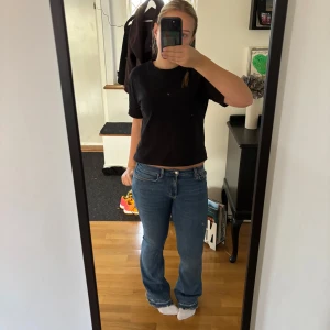 Gina Tricot Bootcut low waist Perfect Jeans Blå - Säljer ett par blåa Bootcut jeans från Gina Tricot. Byxorna kan vara lågmidjade men även lite högre beror på kroppsform. Storlek 38 och är uppsprättade längst ner men annars bra kvalitet. Byxorna köptes för 549kr men säljer för 180kr. 