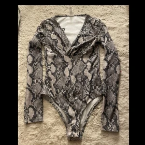 snake print body - lång armad body med snake print från H&M i storlek xs med är stretchig i matreal 