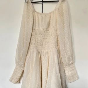 Krämvit mini dress  - Off white mini dress med ballongärm med flowy nederdel, passar bra till midsommar eller studenten!