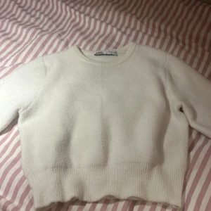 Vit tröja från ZARA - Säljer en superfin vit tröja från ZARA i storlek S. Den är perfekt för både höst och vinter med sin mysiga och varma känsla. Tröjan har trekvarts ärmar och en ribbad kant vid ärmslut och nederkant. Den är i nyskick och passar perfekt.