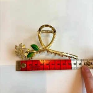 Guldig stor hårklämma med vit blomma håraccessoar hårspänne hårnål - Hårklämma med blomma i guld. Ca 11 cm lång och 4 cm bred som ni kan se på bilden.  Perfekt accessoar för vardag och fest Hårklämman är ny och oanvänd