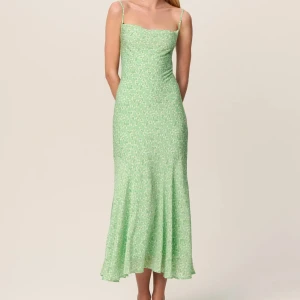 Ljusgrön klänning från ADOORE - Säljer en superfin ljusgrön klänning från ADOORE. Den har ett blommigt mönster,smala axelband och en snörning i ryggen