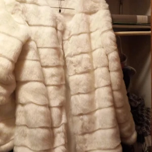 Vinterjacka päls  - Jackan är i nyskick är storlek m inte använd den är vit fuskpäls med små knappar att stänga varm och skön står tyvärr bara i garderoben därför säljer jag den nu men den är väldigt fin