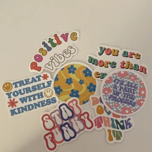 Klistermärken med positiva budskap - Ett set med färgglada klistermärken som sprider positiva vibbar. Designen är lekfull med blommönster och retroinspirerade typsnitt i olika färger som röd, blå, gul och grön. Perfekt för att dekorera din laptop, anteckningsbok eller vägg