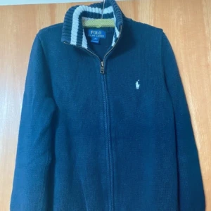 Ralph Lauren tröja  - Tja! Lägger nu ut en intressekoll på denna riktigt snygga Ralph Lauren tröja. Tröjan är marinblå och är i storlek 10 - 12. Tröjan är också i bra skick. Skriv gärna ett pris som du är villig att betala. Var inte heller rädd för att skriva någon fråga.