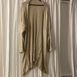 Stickad tröja - Beige lång stickad kofta har använt några gånger. Bra skick.