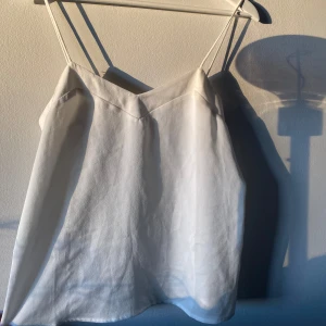 Vit linnetopp från MNG - Säljer vit linnetopp från MNG med smala axelband och en mjukt och tunt tyg (ej see through). Knappast använd.
