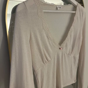 Vit topp - Fin vit topp med en ros som knyter samman spetsdetaljen. Ger lite Elena Gilbert vibe 