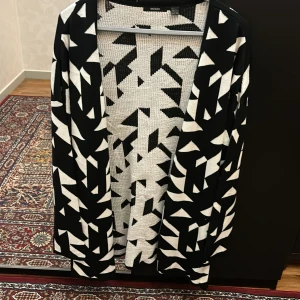 Svartvit mönstrad kofta från Gina Tricot - Säljer en supercool svartvit kofta från Esmara med geometriskt mönster. Den är långärmad och perfekt för att ge lite extra stil till din outfit. Koftan är i bra skick och passar för både vardag och fest! Köpte för 500