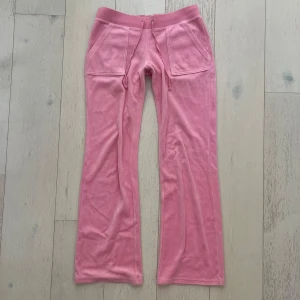 Lågmidjade byxor Juicy Couture  - Så så fina Lågmidjade och utsvängda mjukisbyxor från Juicy Couture i den äldre mer Lågmidjade modellen. Superbra skick, säljer då de inte längre passar 🩷 midjemått 38, grenhöjd 20, innerbenslängd 77 och längd 98 🩷