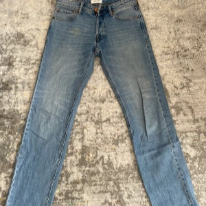 Blå jeans från Jack & Jones - Säljer ett par blå jeans från Jack & Jones. De har en snygg straight fit och är i bra skick. Jeansen har en knappgylf och fem fickor. Passar perfekt till både t-shirt och skjorta! Missfärgad på framsidan men annars är allt perfekt. 