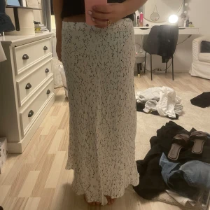 Vit långkjol med blommönster - Säljer en superfin vit långkjol med ett svart blommönster. Kjolen är perfekt för sommardagar och har en skön och luftig passform. Den är i storlek S och passar perfekt till sommaren😇🥰 Den är helt ny och aldrig använd men köpt nu från secondhand❤️