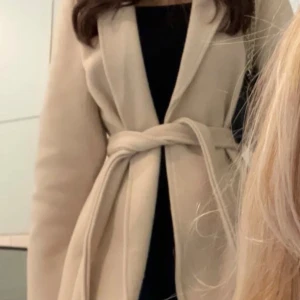 Beige höstkappa - Säljer denna mysiga beiga kappan från boohoo. Använt den i några få gånger, men den är i väldigt gott skick. Storleken är 36, men jag skulle säga att den passar som en xs. Färgen är beige aktig och den har inga fickor. Passar perfekt nu till hösten. 