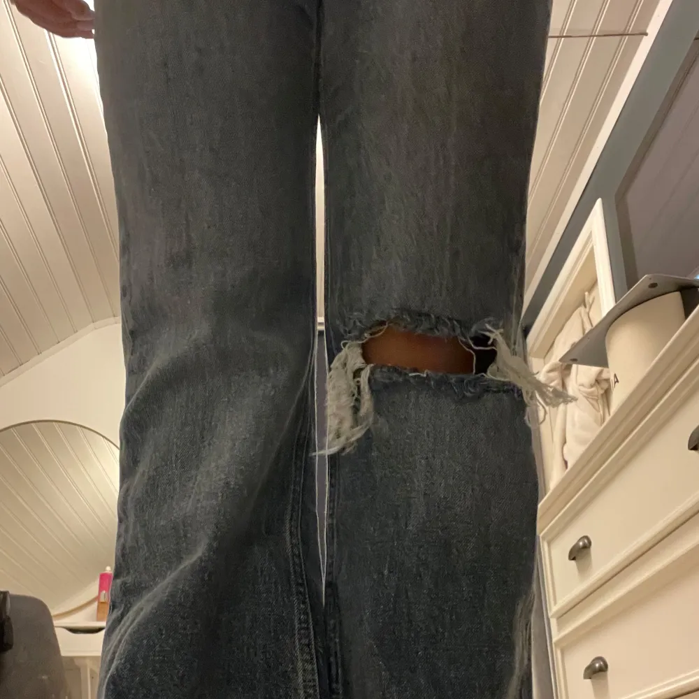 Säljer ett par snygga blå jeans från gina tricot (perfect jeans) i storlek 36. De har en straight passform och är högmidjade. Jeansen har slitna detaljer vid knäna och en mörkblå färg, dom är uppsydda ca 10 cm men går att sprätta upp❤️❤️ Är 167 cm. Jeans & Byxor.