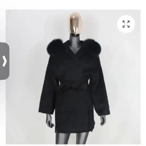 Svart kappa med päls - Elegant svart kappa med stora pälsdetaljer vid axlarna och ett knytbälte i midjan. Perfekt för vintern och våran har haft den några gånger men inte så mycket. Skriv för flera bilder