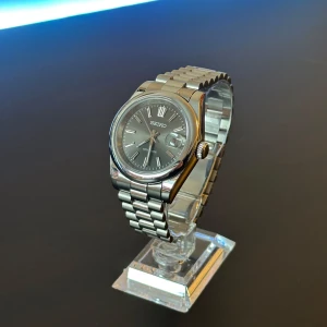Seiko Mod Datejust - Nybyggd Seiko mod Datejust 40mm, NH35 automatiskt urverk, Safir glas, Stainless steel presidential länk (kan även anpassa storleken, om önskat) Grå urtavla med sunburst-effekt (skimrar/skiftar färg i olika ljus) Lume visare (lyser i mörkret), box ingår