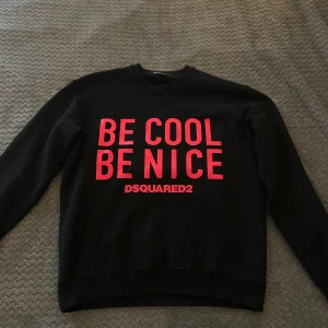 Svart sweatshirt från DSQUARED2 - Säljer en svart sweatshirt från DSQUARED2 med rosa text på framsidan. Tröjan är använd en gång. Köpt tröjan för 3100.