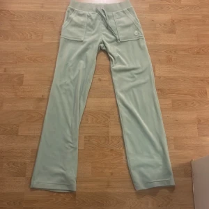 Ljusa gröna mjukisbyxor med fickor - Snygga ljusgröna mjukisbyxor med bred resår i midjan och snörning. Byxorna har praktiska fickor både fram och bak med knappar. Perfekta för en avslappnad stil.