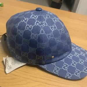 Blå keps med monogrammönster - Hej säljer min nya Gucci keps som är helt oanvänd och fräsch. Den hära gucci modellen är jätte sällsynt och fin. Säljer pågrund av att den inte passar mig.