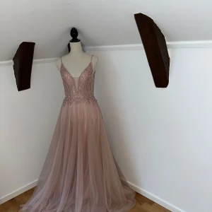 Balklänning  - KOLLAR INTRESSET Ljusrosa balklänning från märket Mascara. Storlek 38, TTS. Skriv privat om ni vill veta mått. Har upptäckt defekter på tyllen, syns ej vid användning men har gått sönder på vissa ställen