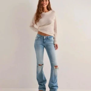 Ljusblå bootcut jeans med slitningar - Snygga ljusblå bootcut jeans med slitningar på knäna. Använda men bra skick, köpte för 700 säljer för 500, stl 32 ( lågmidjade ) kommer ej till användning 🥰🥰 💕 skriv privat vid frågor och innan köp nu