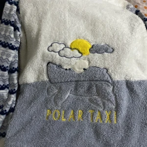 Mysig fleecepyjamas med mönster - Säljer en supermysig fleecepyjamas med ett coolt 'Polar Taxi'-tryck på framsidan. Tröjan har långa ärmar med ett blått och vitt mönster. Byxorna matchar med samma mönster och har elastisk midja för extra komfort. Perfekt för kalla nätter. Över och under delen är i storlek S och byxorna passa typ som M köpte dom för 200kr och säljer för 80kr 