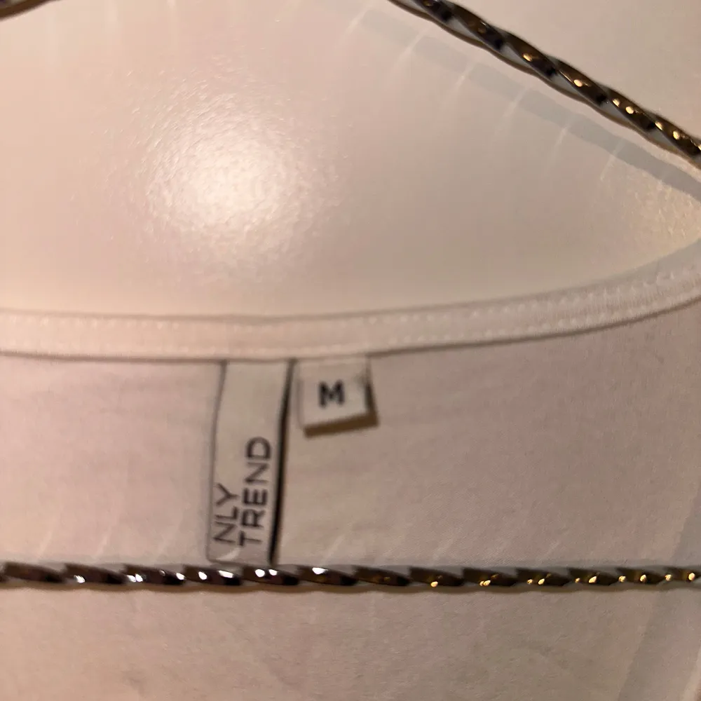 Säljer en stilren vit långärmad topp från NELLY med v-ringning och rynkdetalj framtill. Perfekt för en chic och enkel look.. Yläosat.