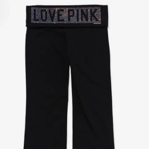 Victoria secret SÖKER BYTEN BARA - Snygga svarta byxor med en glittrig text 'LOVE PINK' på midjan. Perfekta för en avslappnad stil med en touch av glamour. Byxorna har en bekväm passform och är gjorda i ett mjukt material.