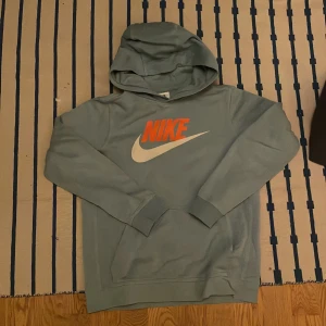 Grå och svart hoodie från The North Face - Säljer en snygg grå och svart hoodie från The North Face med dragkedja och huva. Perfekt för kyliga dagar och har en stilren design med logotyp på bröstet. Passar bra till både vardag och träning.