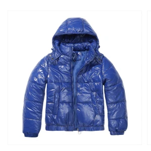 Blå glansig pufferjacka med huva från Dressy.se - Snygg blå pufferjacka med glansig yta och praktisk huva. Jackan har dragkedja framtill och långa ärmar. Perfekt för kyliga dagar när du vill hålla värmen med stil.