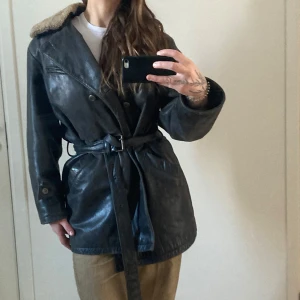 Vintage läderjacka med fårskinn - Äkta vintage läderjacka med fårskinnskrage och skärp i midjan. Mycket fint skick även om det syns att det är vintage. Jag som är en S/M bär den oversize 