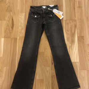 Svarta bootcut jeans från Gina Tricot - Snygga svarta bootcut jeans från Gina Tricot med låg midja och framfickor. Perfekta för en trendig look. Märkesdetaljer på fickorna ger en extra touch.Jätte bra stick aldrig använda helt nya. Pris kan diskuteras 