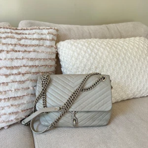 Rebecca Minkoff handväska  - En grå Rebecca Minkoff väska med silverdetaljer inköpt på NK för några år sedan. Sparsamt använd men med mindre täcken på användning. Inköpt för ca 4000 kr. 