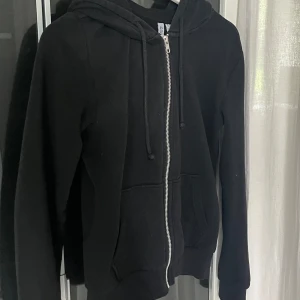 Svart hoddie  - Snygg! Älskar själv hur den sitter tajtare nertill midjan!! Säljer då jag har två likadana 