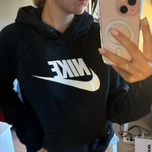 Svart hoodie från Nike - Säljer en svart hoodie från Nike med den klassiska loggan i vitt på framsidan. Den är superbekväm och perfekt för både chill och träning. Hoodien har långa ärmar och en stor ficka framtill. Perfekt för höst och vinter!