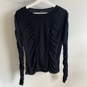 Långärmad tröja  - Långärmad tröja från Gina tricot med ryschade detaljer på tröjan och ärmarna. Lappen för tvättråd och material är bortklippt. Använd ett par gånger, och är i nyskick. 