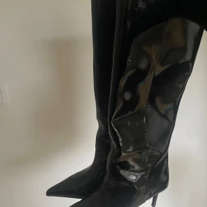 Svarta boots - Snygga svarta stövlar i syntetmaterial med en glansig finish. Endast använd en gång.. Säljer pga ej har användning för dem🦾