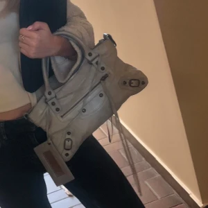 Balenciaga city bag - Balenciaga city bag i modellen First. Så snygg ljus blå färg. Köpt på Collectors Cage för 6132 danska kronor = 9450kr i november. Den var köpt vintage och har därav tecken på användning. Har en liten fläck som knappt är synbar på baksidan (se sista bilden), men annars i bra skick. Skriv för fler frågor!