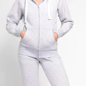 Russemerch Grå hoodie med dragkedja - Säljer en stilren grå hoodie med dragkedja och justerbar huva. Tröjan har långa ärmar och praktiska fickor framtill. Perfekt för en avslappnad look. Passar bra till både jeans och mjukisbyxor.