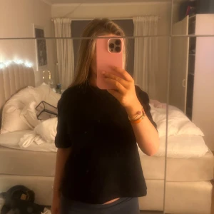 Svart kortärmad topp - Säljer en stilren svart kortärmad topp. Perfekt för en enkel och snygg look. Passar bra till både jeans och kjol.