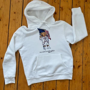 Vit hoodie från Ralph Lauren - Säljer en vit hoodie från Ralph Lauren i fint skick. Hoodien har en stor ficka framtill och justerbar dragsko i huvan 🐻🇺🇸 (Nypris ca. 2499 kr)