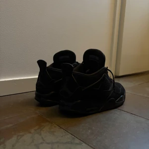 Svarta Nike Air Jordans - Snygga helsvarta Nike Air Jordans med klassisk design. Skorna har snörning och är tillverkade i skinn och syntetmaterial. Perfekta för dig som gillar en stilren look. Säljer mina Jordan 4 black cats för dom har blivit för små, såklart äkta!