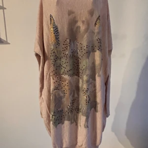 Ljusrosa tröja med djurmotiv - Säljer en ljusrosa tröja med ett unikt djurmotiv och färgade pärlor på framsidan. Tröjan har långa ärmar och är oversized, perfekt för en avslappnad stil. 🦓🦜