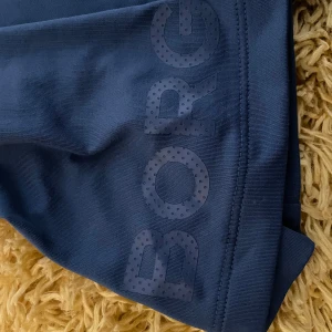 Blå träningsshorts från Björn Borg - Snygga blå träningsshorts från Björn Borg med tryckt logga på benet. Perfekta för gymmet eller löprundan. Tillverkade i ett lätt och bekvämt material som andas.